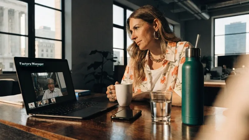 A brand owner having a video call with a clothing factory manager.